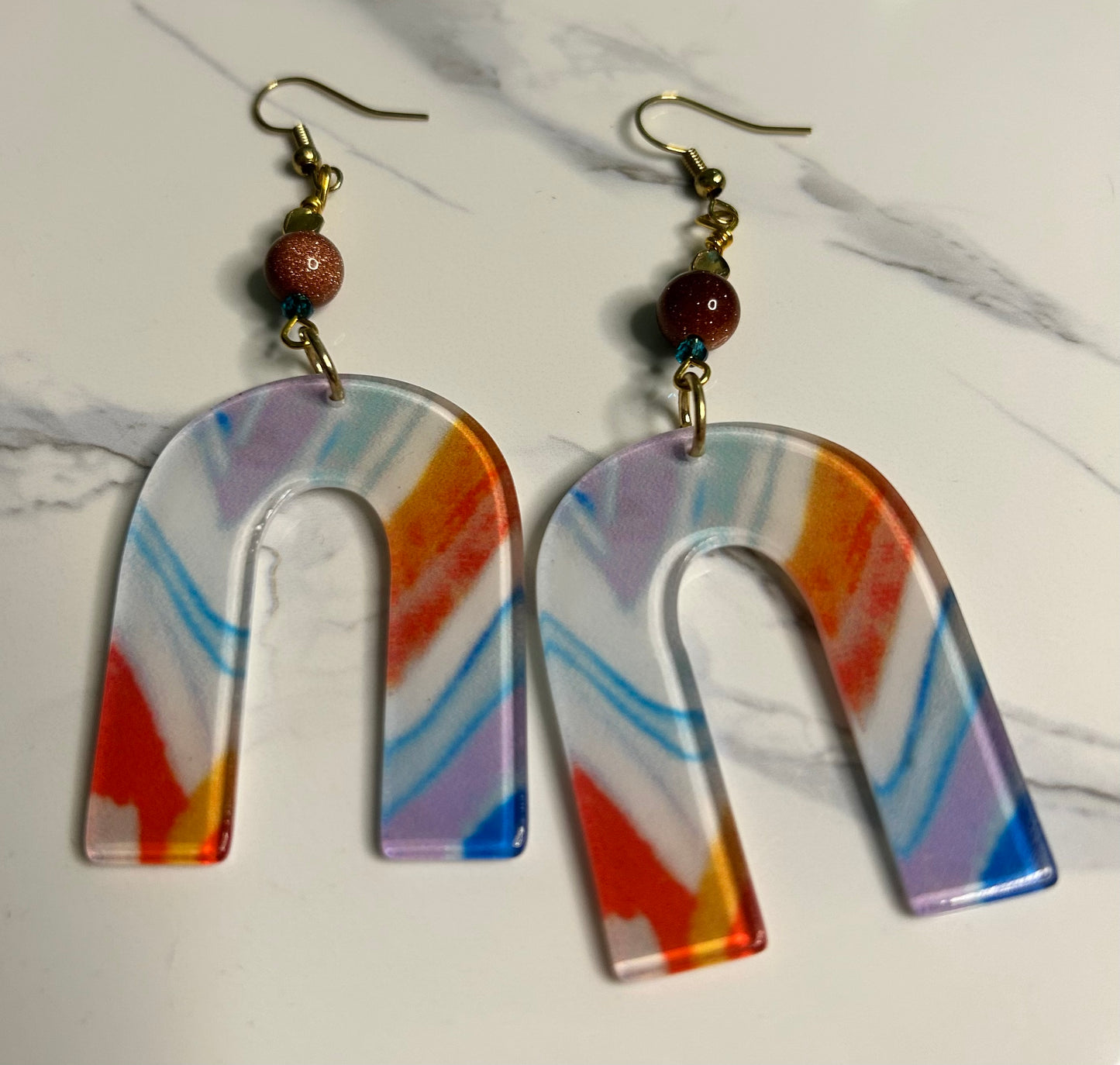 Fun burnt orange, blue and white upside down U-shape with sparkly and blue beads and gold findings. Length: about 2 1/2 inches Weight: .25 ounces