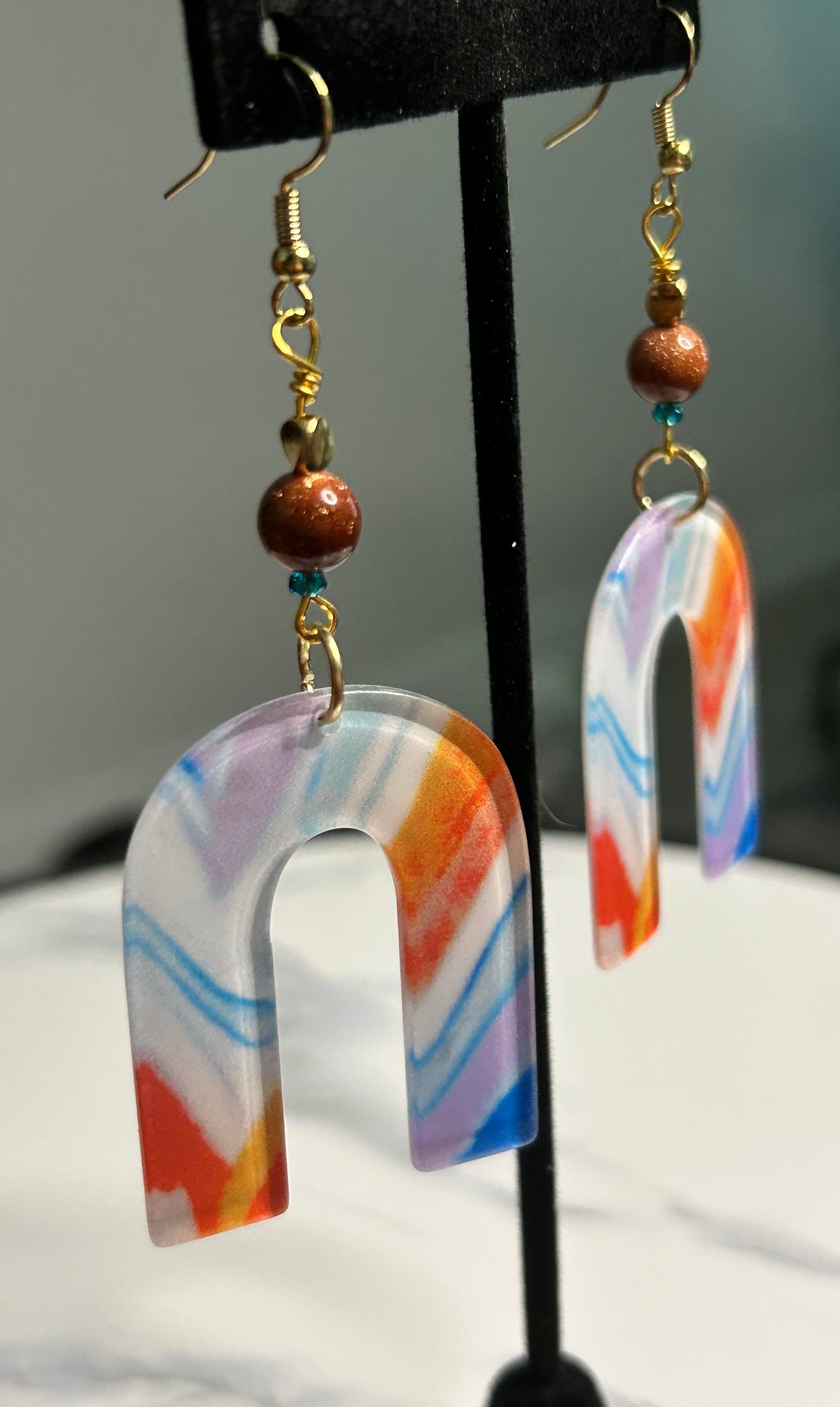 Fun burnt orange, blue and white upside down U-shape with sparkly and blue beads and gold findings. Length: about 2 1/2 inches Weight: .25 ounces